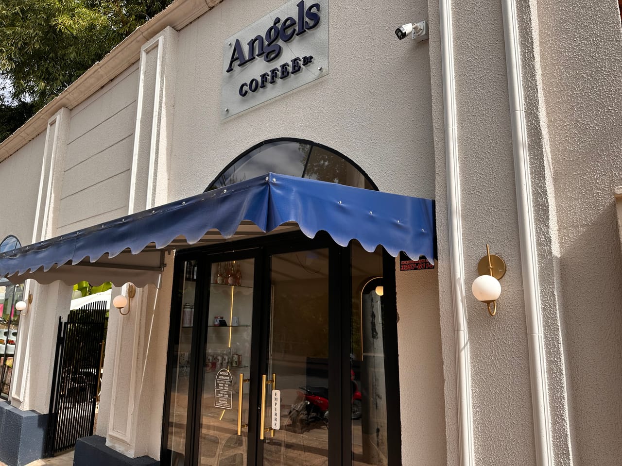 Fachada da cafeteria Angels Coffee Br com toldo azul e placa, no Centro de Uruaçu-GO